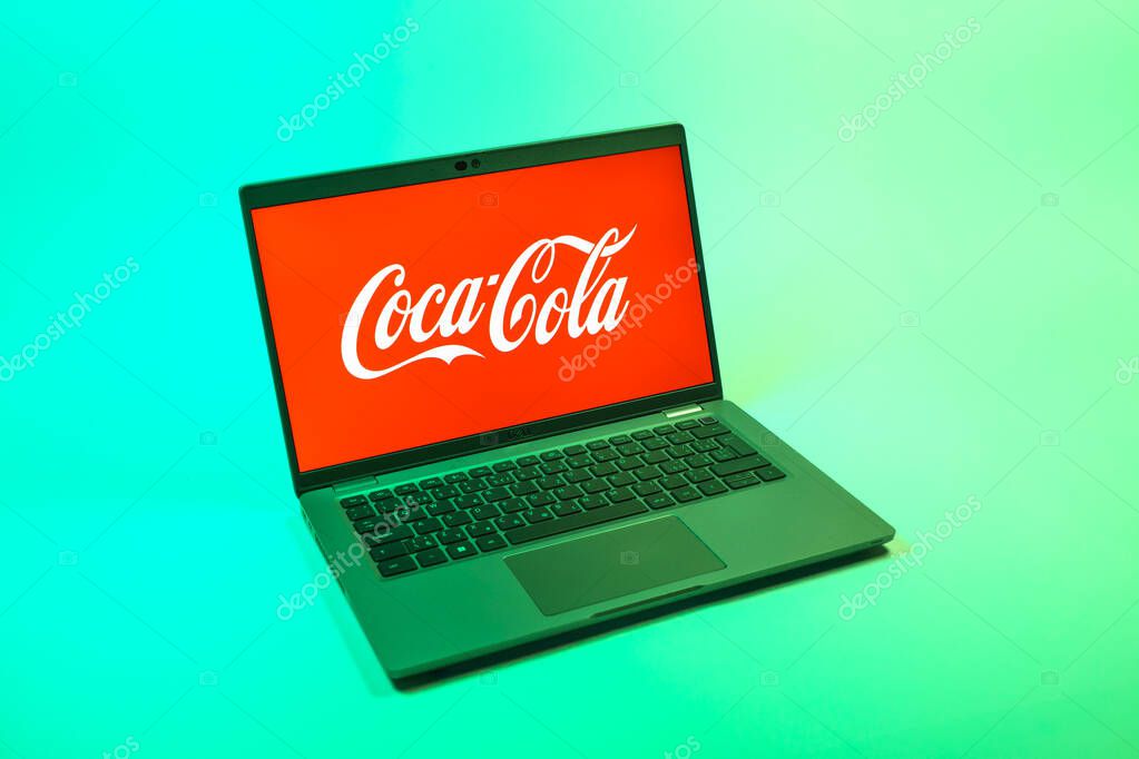 Prague, Czechia - 08 12 2025: A top-down view of a laptop on a uniform background displaying the Coca-Cola logo. Coca-Cola is a beverage company known for its soft drinks.