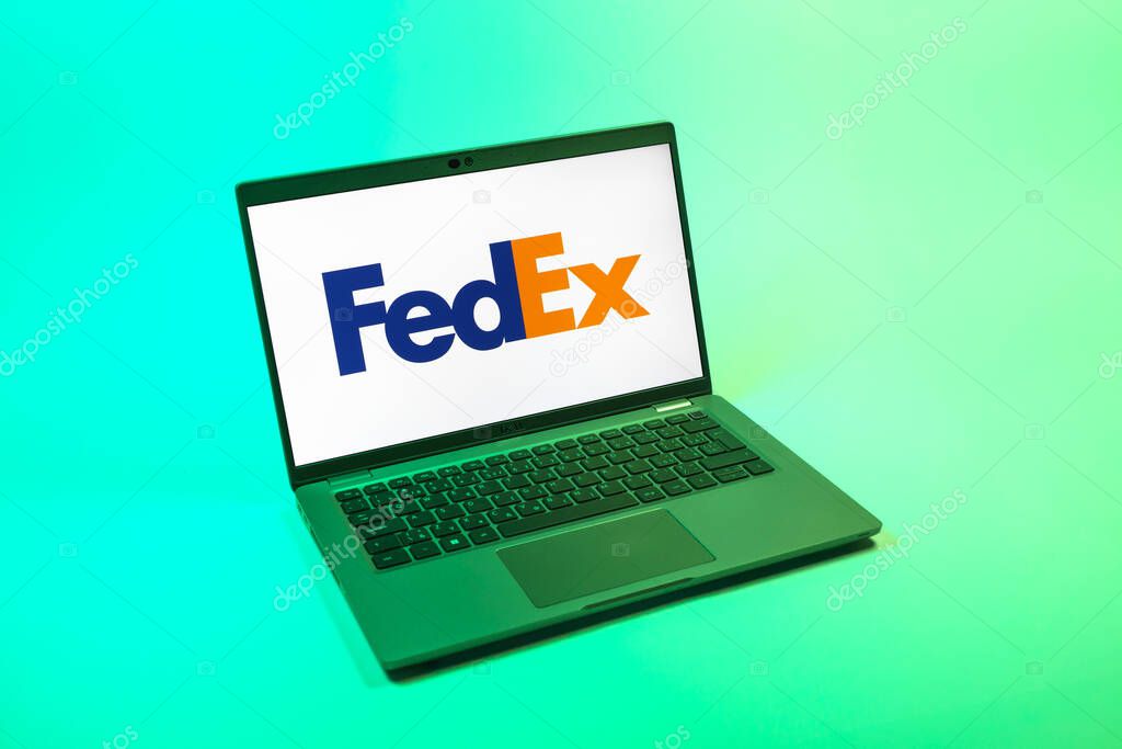 Prague, Czechia - 08 12 2025: A top-down view of a laptop on a uniform background displaying the FedEX logo. FedEX is a logistics company providing shipping and courier services.