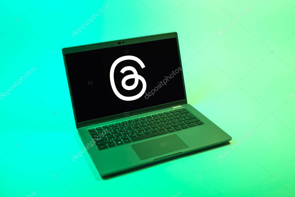 Prague, Czechia - 08 12 2025: A top-down view of a laptop on a uniform background displaying the Threads logo. Threads is a social media platform for sharing short posts and updates.