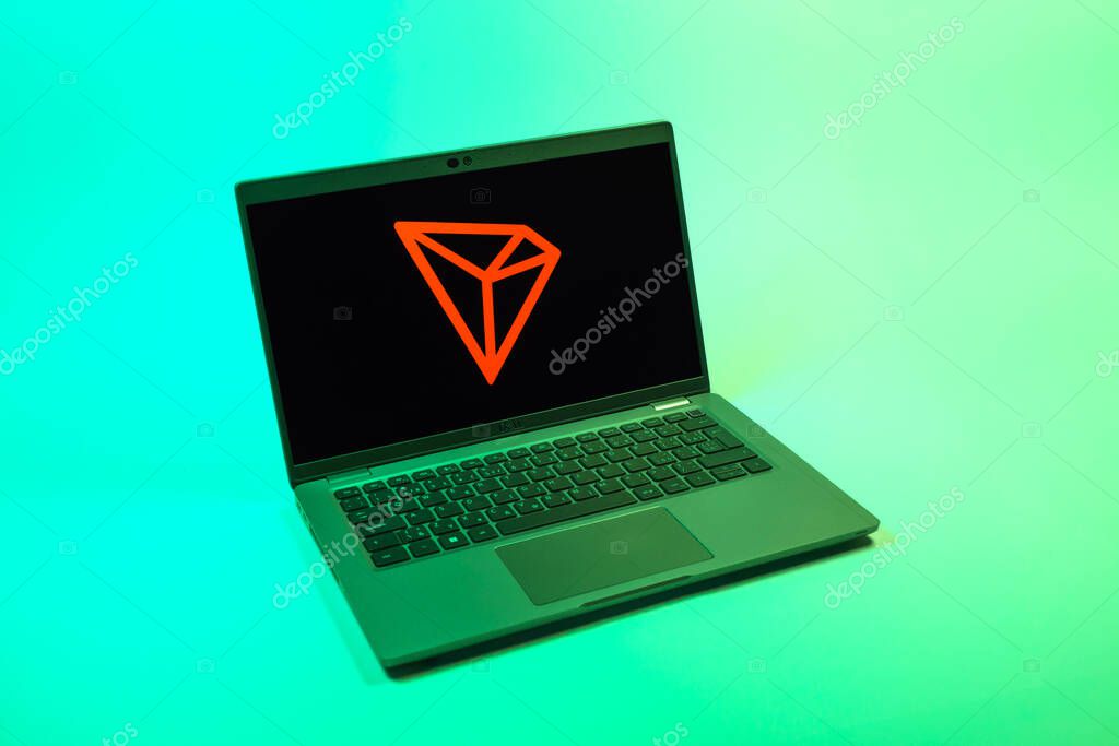 Prague, Czechia - 08 12 2025: A top-down view of a laptop on a uniform background displaying the Tron logo. Tron is a blockchain platform for decentralized applications.