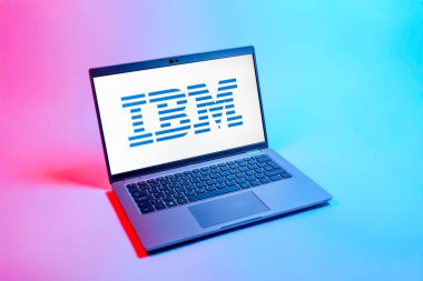 Prag, Çek Cumhuriyeti - 08 12 2025: Tek bir arkaplanda IBM logosunu gösteren bir dizüstü bilgisayarın yukarıdan aşağı görüntüsü. IBM yazılım, donanım ve danışmanlık sunan bir teknoloji şirketidir..