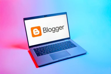 Prag, Çek Cumhuriyeti - 08 12 2025: Blog logosunu gösteren tek tip bir arkaplanda bir dizüstü bilgisayarın yukarıdan aşağı görüntüsü. Blogger blog oluşturma ve yayınlama için bir platformdur.