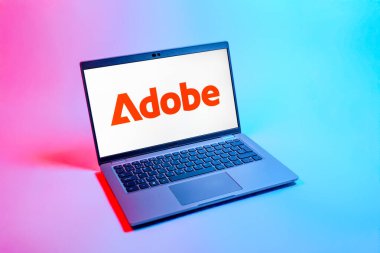 Prag, Çek Cumhuriyeti - 08 12 2025: Tek bir arkaplanda Adobe logosunu gösteren dizüstü bilgisayarın yukarıdan görünüşü. Adobe yaratıcı araçlar ve hizmetler sunan bir yazılım şirketidir..