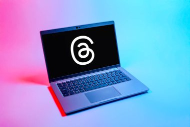 Prag, Çek Cumhuriyeti - 08 12 2025: Dizüstü bilgisayarın tek tip arkaplanda ipliklerin logosunu gösteren yukarıdan aşağı görüntüsü. Tartışmalar, kısa gönderileri ve güncellemeleri paylaşmak için bir sosyal medya platformudur.