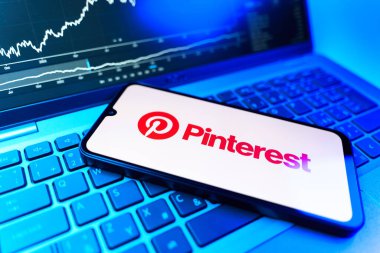 Prag, Çek Cumhuriyeti - 09 02 2025: Pinterest logosunu gösteren dizüstü bilgisayarlı telefon. Pinterest fikirleri görsel olarak keşfetmek ve kaydetmek için bir platformdur..