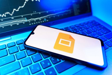 Prag, Çek Cumhuriyeti - 09 02 2025: Google Slides logosunu gösteren dizüstü bilgisayarlı telefon. Google Slides sunumlar ve slayt gösterileri oluşturmak için bir platformdur.