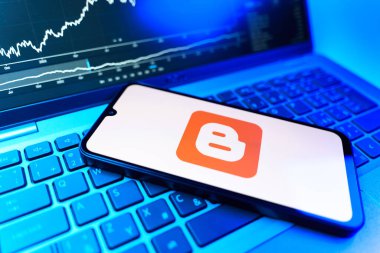 Prag, Çek Cumhuriyeti - 09 02 2025: Blog logosunu gösteren dizüstü bilgisayarlı telefon. Blogger blog oluşturma ve yayınlama için bir platformdur.