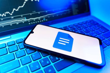 Prag, Çek Cumhuriyeti - 09 02 2025: Google Docs logosunu gösteren dizüstü bilgisayarlı telefon. Google Docs metin belgeleri oluşturmak ve düzenlemek için bir platformdur.