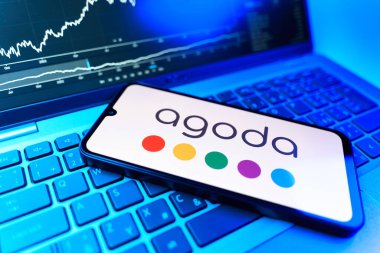 Prag, Çek Cumhuriyeti - 09 02 2025: Agoda logosunu gösteren dizüstü bilgisayarlı telefon. Agoda, otelleri ve seyahat yerlerini ayırtmak için bir platform..