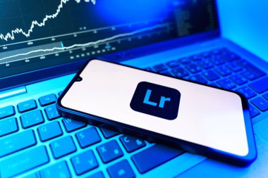 Prag, Çek Cumhuriyeti - 09 02 2025: Lightroom logosunu gösteren dizüstü bilgisayarlı telefon. Lightroom fotoğraf düzenleme ve yönetim için bir yazılımdır..