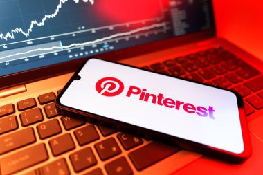 Prag, Çek Cumhuriyeti - 09 02 2025: Pinterest logosunu gösteren dizüstü bilgisayarlı telefon. Pinterest fikirleri görsel olarak keşfetmek ve kaydetmek için bir platformdur..