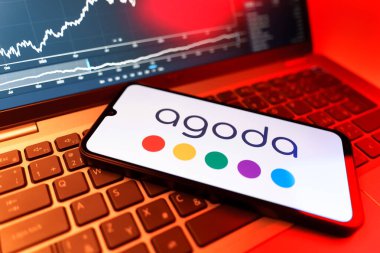 Prag, Çek Cumhuriyeti - 09 02 2025: Agoda logosunu gösteren dizüstü bilgisayarlı telefon. Agoda, otelleri ve seyahat yerlerini ayırtmak için bir platform..
