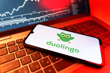 Prag, Çek Cumhuriyeti - 09 02 2025: Duolingo logosunu gösteren dizüstü bilgisayarlı telefon. Duolingo interaktif olarak dil öğrenmek için bir platformdur..