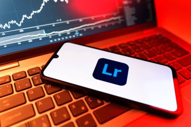 Prag, Çek Cumhuriyeti - 09 02 2025: Lightroom logosunu gösteren dizüstü bilgisayarlı telefon. Lightroom fotoğraf düzenleme ve yönetim için bir yazılımdır..