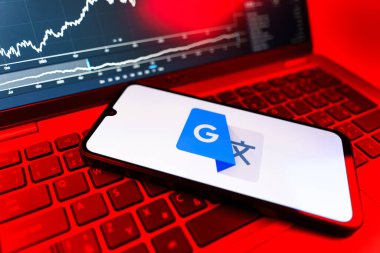 Prag, Çek Cumhuriyeti - 09 02 2025: Google Translate logosunu gösteren dizüstü bilgisayarlı telefon. Google Çevirisi metni ve konuşmayı diller arası çevirmek için bir platformdur..