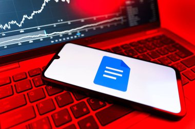 Prag, Çek Cumhuriyeti - 09 02 2025: Google Docs logosunu gösteren dizüstü bilgisayarlı telefon. Google Docs metin belgeleri oluşturmak ve düzenlemek için bir platformdur.