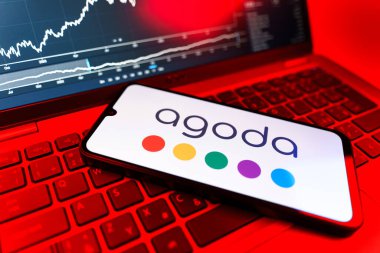 Prag, Çek Cumhuriyeti - 09 02 2025: Agoda logosunu gösteren dizüstü bilgisayarlı telefon. Agoda, otelleri ve seyahat yerlerini ayırtmak için bir platform..