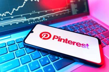 Prag, Çek Cumhuriyeti - 09 02 2025: Pinterest logosunu gösteren dizüstü bilgisayarlı telefon. Pinterest fikirleri görsel olarak keşfetmek ve kaydetmek için bir platformdur..