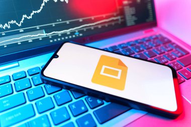 Prag, Çek Cumhuriyeti - 09 02 2025: Google Slides logosunu gösteren dizüstü bilgisayarlı telefon. Google Slides sunumlar ve slayt gösterileri oluşturmak için bir platformdur.