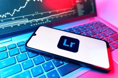Prag, Çek Cumhuriyeti - 09 02 2025: Lightroom logosunu gösteren dizüstü bilgisayarlı telefon. Lightroom fotoğraf düzenleme ve yönetim için bir yazılımdır..