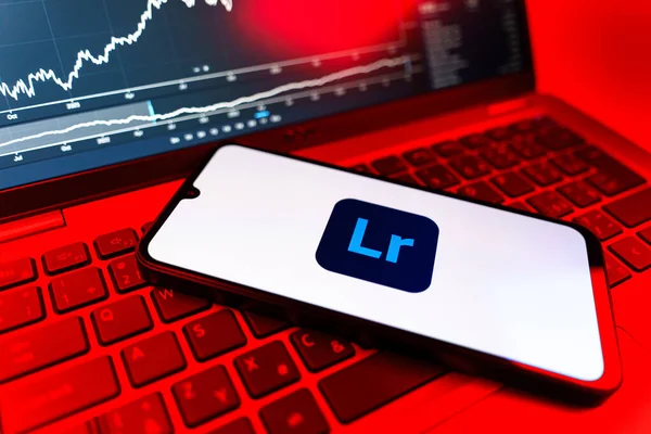 Prag, Çek Cumhuriyeti - 09 02 2025: Lightroom logosunu gösteren dizüstü bilgisayarlı telefon. Lightroom fotoğraf düzenleme ve yönetim için bir yazılımdır..