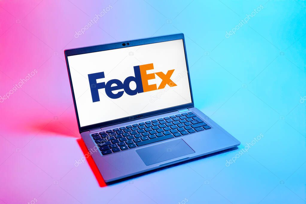 Prague, Czechia - 08 12 2025: A top-down view of a laptop on a uniform background displaying the FedEX logo. FedEX is a logistics company providing shipping and courier services.