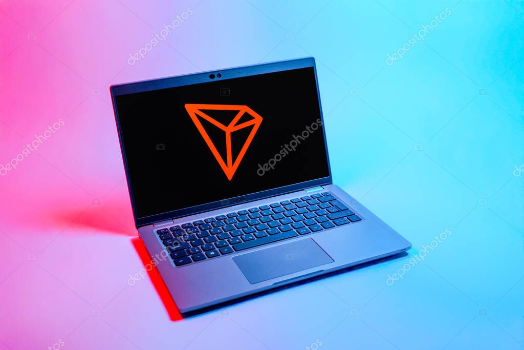 Prague, Czechia - 08 12 2025: A top-down view of a laptop on a uniform background displaying the Tron logo. Tron is a blockchain platform for decentralized applications.