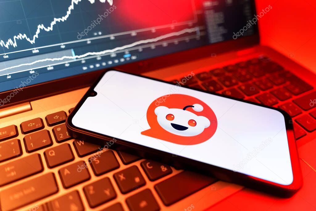 Prague, Czechia - 09 02 2025: Phone on laptop with stock chart showing Reddit logo. Reddit is a platform for discussion, news, and community content.