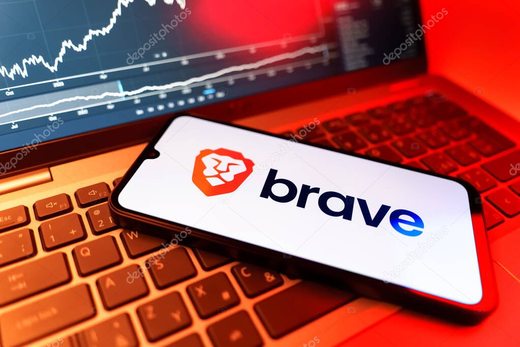 Prague, Czechia - 09 02 2025: Phone on laptop with stock chart showing Brave logo. Brave is a web browser focused on privacy and speed.