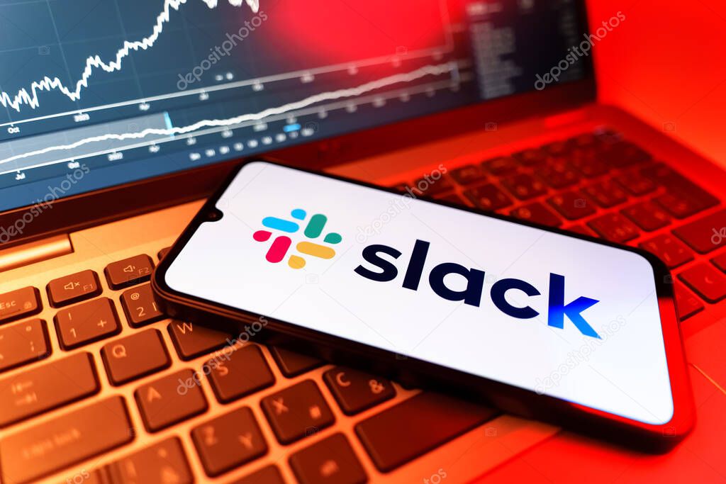 Prague, Czechia - 09 02 2025: Phone on laptop with stock chart showing Slack logo. Slack is a platform for team messaging and workplace communication.