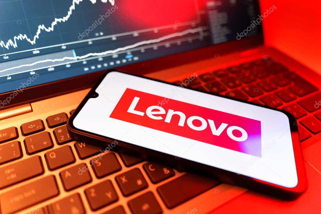 Prague, Czechia - 09 02 2025: Phone on laptop with stock chart showing Lenovo logo. Lenovo is a technology company producing computers and electronics.