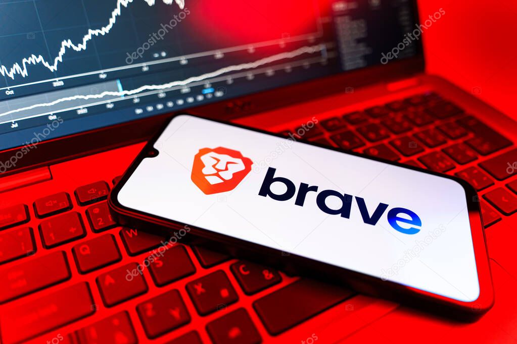 Prague, Czechia - 09 02 2025: Phone on laptop with stock chart showing Brave logo. Brave is a web browser focused on privacy and speed.