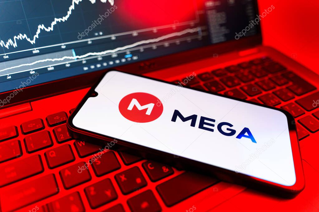 Prague, Czechia - 09 02 2025: Phone on laptop with stock chart showing Mega logo. Mega is a platform for cloud storage with encrypted file sharing.