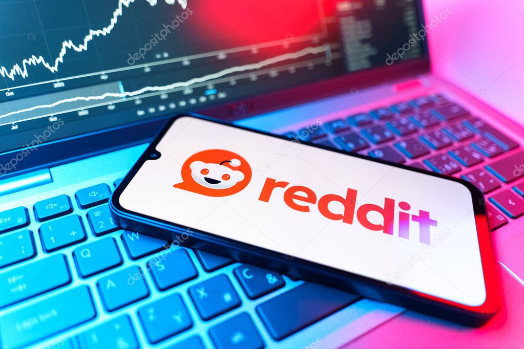 Prague, Czechia - 09 02 2025: Phone on laptop with stock chart showing Reddit logo. Reddit is a platform for discussion, news, and community content.