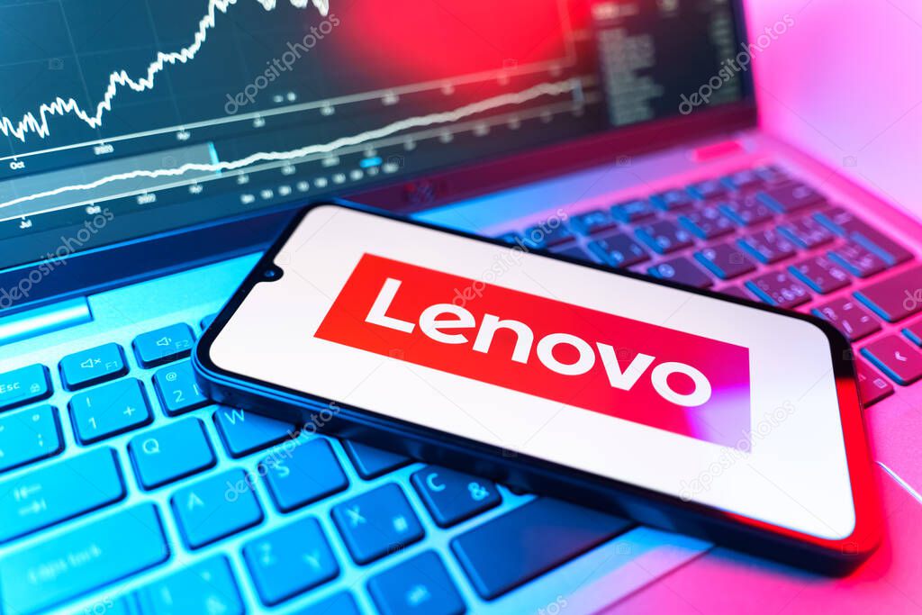 Prague, Czechia - 09 02 2025: Phone on laptop with stock chart showing Lenovo logo. Lenovo is a technology company producing computers and electronics.