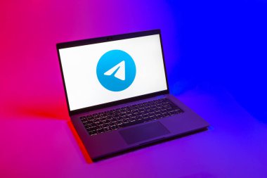 Prag, Çek Cumhuriyeti - 08 12 2025: Tek tip bir arkaplanda Telegram logosunu gösteren bir dizüstü bilgisayarın yukarıdan görünüşü. Telgraf hızlı ve güvenli iletiler için bir uygulamadır.
