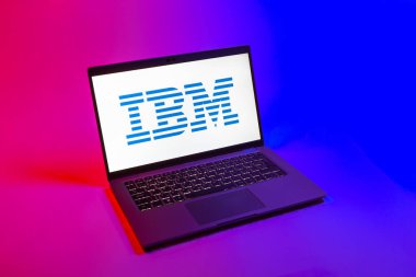 Prag, Çek Cumhuriyeti - 08 12 2025: Tek bir arkaplanda IBM logosunu gösteren bir dizüstü bilgisayarın yukarıdan aşağı görüntüsü. IBM yazılım, donanım ve danışmanlık sunan bir teknoloji şirketidir..