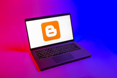 Prag, Çek Cumhuriyeti - 08 12 2025: Blog logosunu gösteren tek tip bir arkaplanda bir dizüstü bilgisayarın yukarıdan aşağı görüntüsü. Blogger blog oluşturma ve yayınlama için bir platformdur.