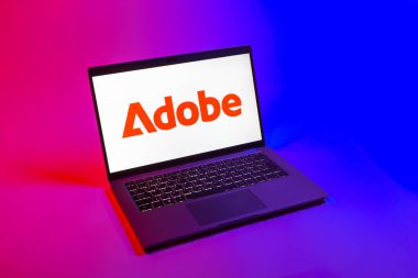 Prag, Çek Cumhuriyeti - 08 12 2025: Tek bir arkaplanda Adobe logosunu gösteren dizüstü bilgisayarın yukarıdan görünüşü. Adobe yaratıcı araçlar ve hizmetler sunan bir yazılım şirketidir..