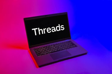 Prag, Çek Cumhuriyeti - 08 12 2025: Dizüstü bilgisayarın tek tip arkaplanda ipliklerin logosunu gösteren yukarıdan aşağı görüntüsü. Tartışmalar, kısa gönderileri ve güncellemeleri paylaşmak için bir sosyal medya platformudur.