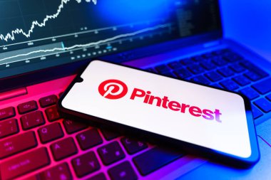 Prag, Çek Cumhuriyeti - 09 02 2025: Pinterest logosunu gösteren dizüstü bilgisayarlı telefon. Pinterest fikirleri görsel olarak keşfetmek ve kaydetmek için bir platformdur..