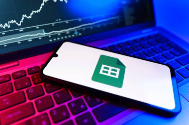 Prag, Çek Cumhuriyeti - 09 02 2025: Google Sheets logosunu gösteren dizüstü bilgisayarlı telefon. Google Sayfalar tablo oluşturmak ve yönetmek için bir platformdur.