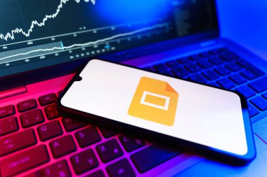 Prag, Çek Cumhuriyeti - 09 02 2025: Google Slides logosunu gösteren dizüstü bilgisayarlı telefon. Google Slides sunumlar ve slayt gösterileri oluşturmak için bir platformdur.