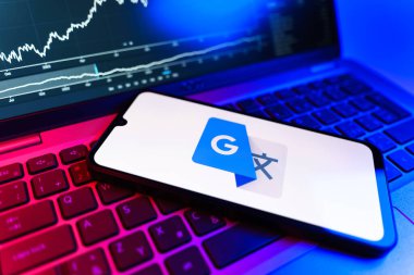 Prag, Çek Cumhuriyeti - 09 02 2025: Google Translate logosunu gösteren dizüstü bilgisayarlı telefon. Google Çevirisi metni ve konuşmayı diller arası çevirmek için bir platformdur..