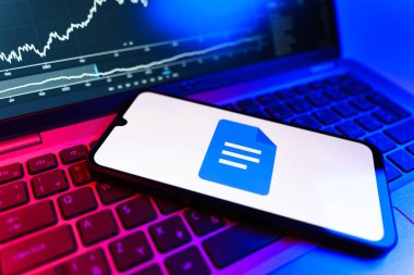 Prag, Çek Cumhuriyeti - 09 02 2025: Google Docs logosunu gösteren dizüstü bilgisayarlı telefon. Google Docs metin belgeleri oluşturmak ve düzenlemek için bir platformdur.