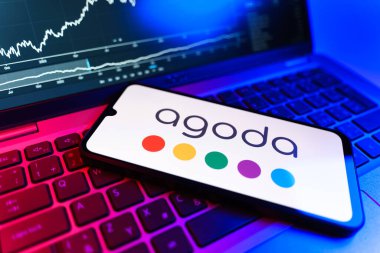 Prag, Çek Cumhuriyeti - 09 02 2025: Agoda logosunu gösteren dizüstü bilgisayarlı telefon. Agoda, otelleri ve seyahat yerlerini ayırtmak için bir platform..