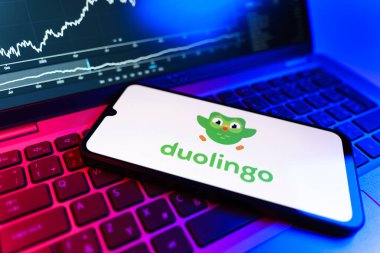 Prag, Çek Cumhuriyeti - 09 02 2025: Duolingo logosunu gösteren dizüstü bilgisayarlı telefon. Duolingo interaktif olarak dil öğrenmek için bir platformdur..