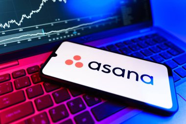 Prag, Çek Cumhuriyeti - 09 02 2025: Asana logosunu gösteren dizüstü bilgisayarlı telefon. Asana görev yönetimi ve takım işbirliği için bir platformdur..
