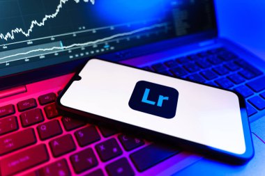 Prag, Çek Cumhuriyeti - 09 02 2025: Lightroom logosunu gösteren dizüstü bilgisayarlı telefon. Lightroom fotoğraf düzenleme ve yönetim için bir yazılımdır..