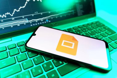 Prag, Çek Cumhuriyeti - 09 02 2025: Google Slides logosunu gösteren dizüstü bilgisayarlı telefon. Google Slides sunumlar ve slayt gösterileri oluşturmak için bir platformdur.